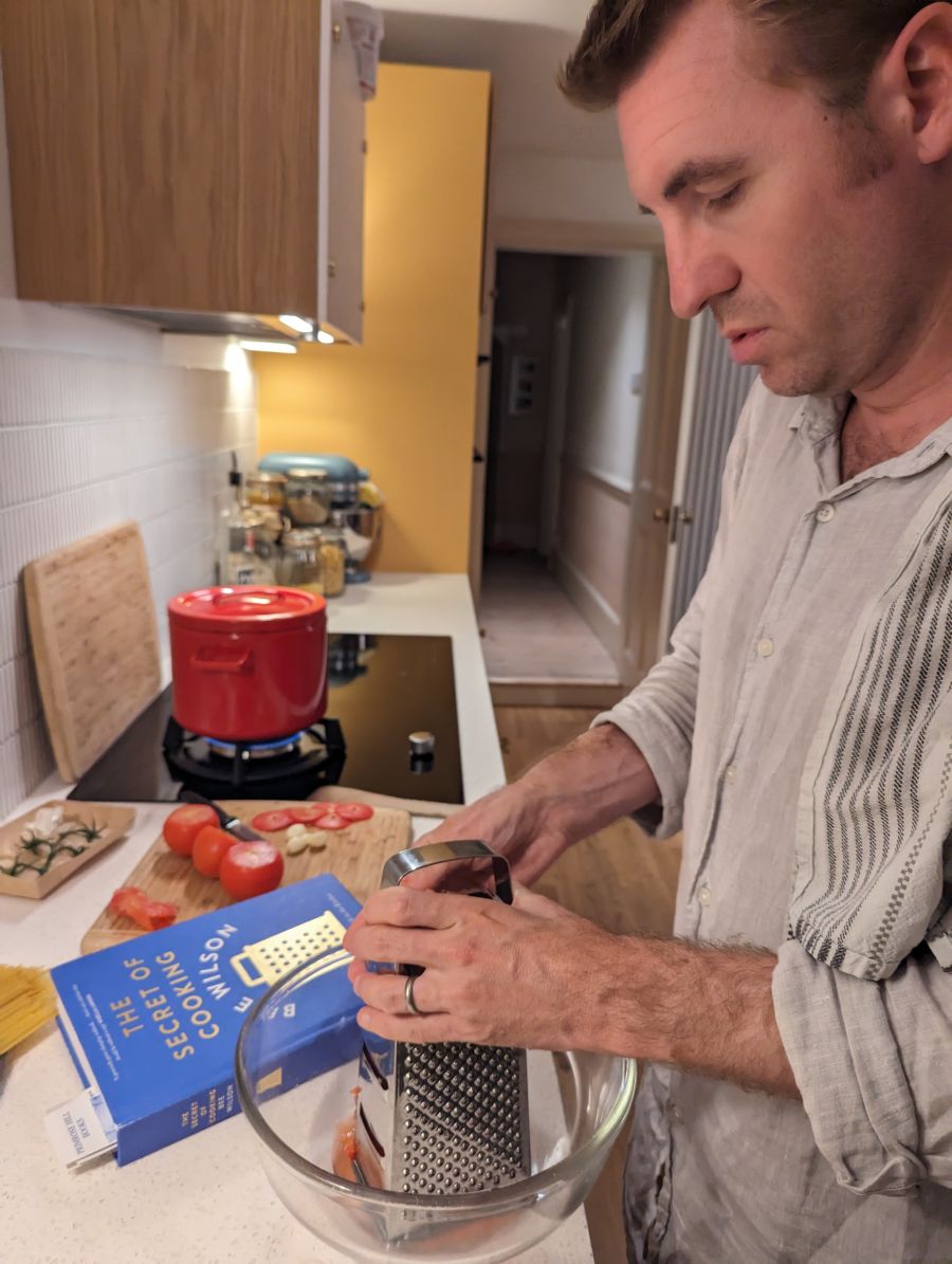 man using a grater in the kitchen.