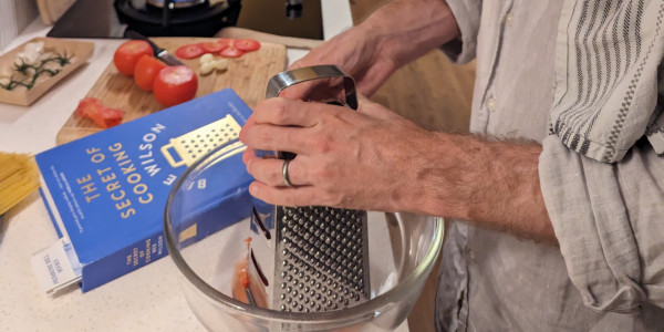 man using a grater in the kitchen.