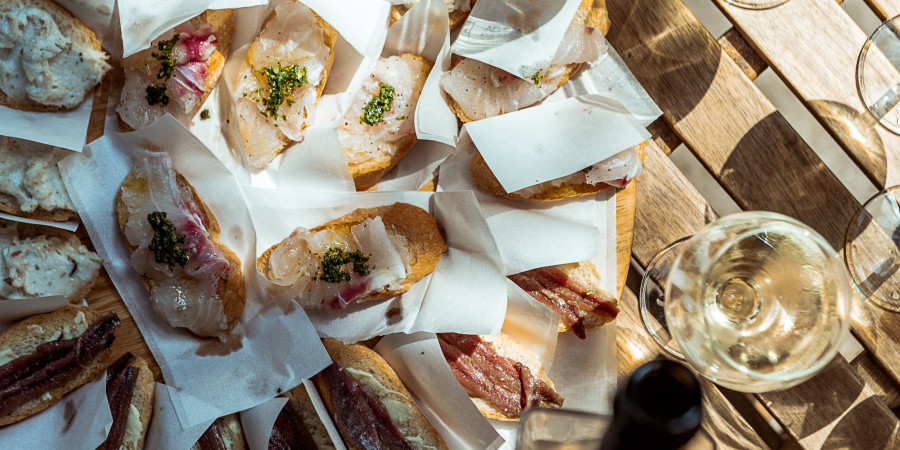 slices of bread with cured meat on a table.
