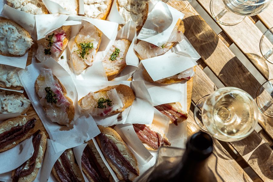 slices of bread with cured meat on a table.