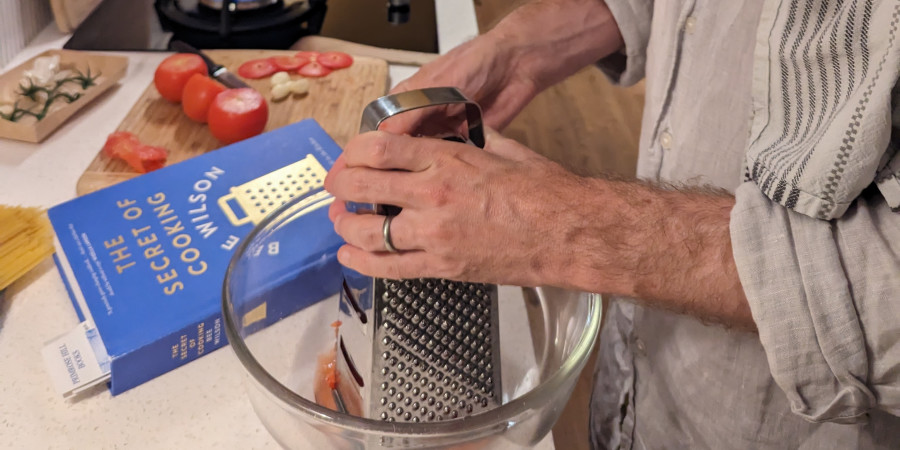 man using a grater in the kitchen.