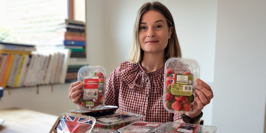 Journalist Sophie Morris holding a selection of supermarket strawberries.
