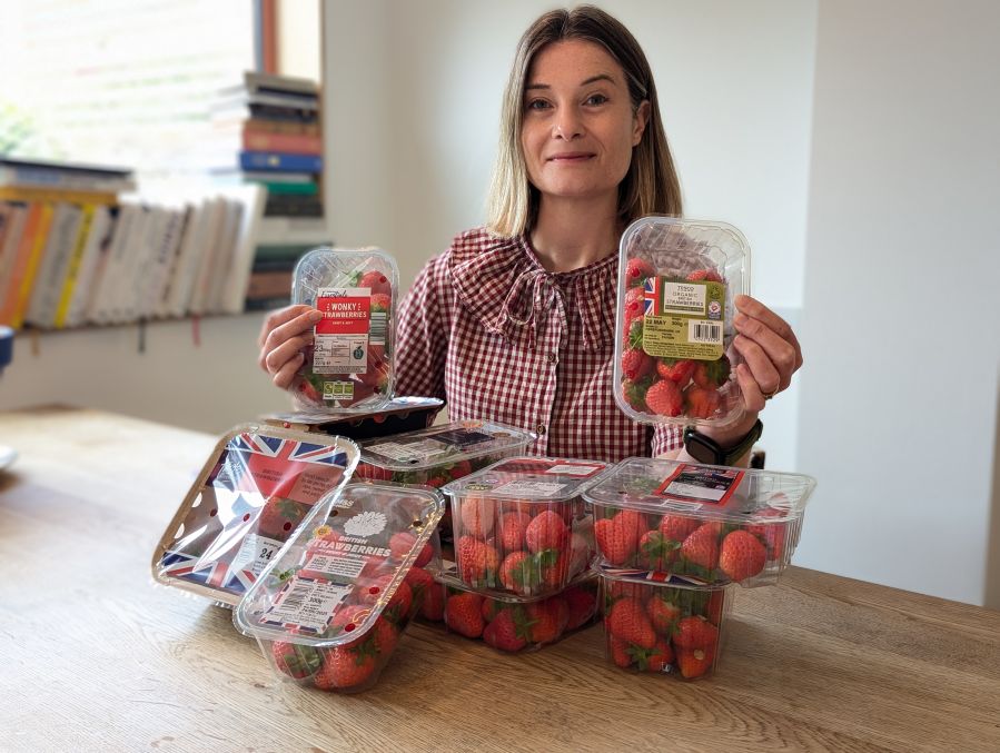 Journalist Sophie Morris holding a selection of supermarket strawberries.