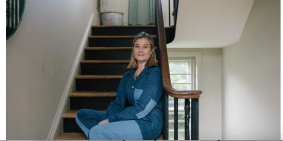 woman sitting on stairs in a house.