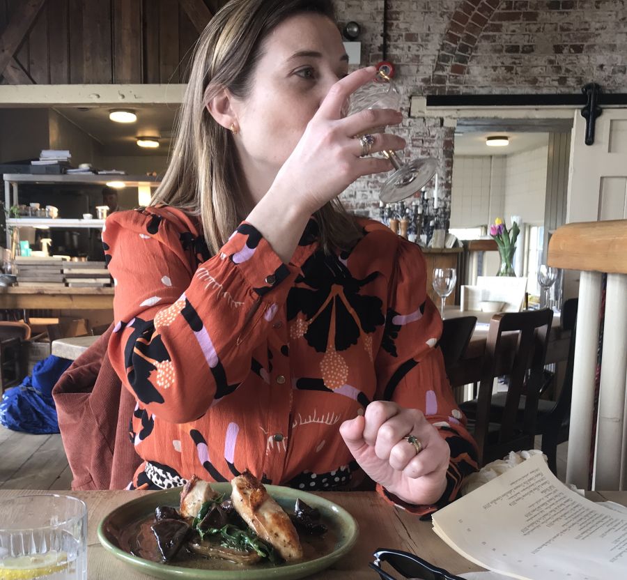 woman drinking with a nice plate of food.