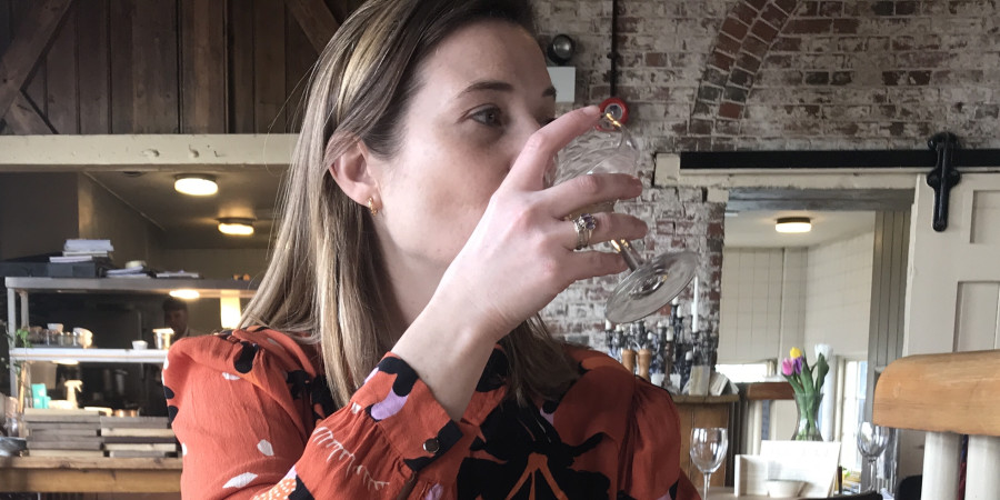 woman drinking with a nice plate of food.