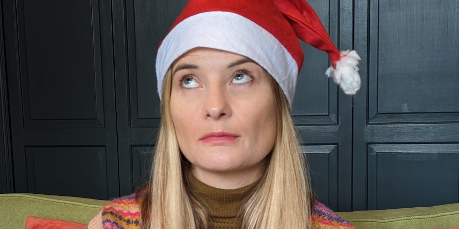 Pretty woman in Santa hat rolling her eyes.