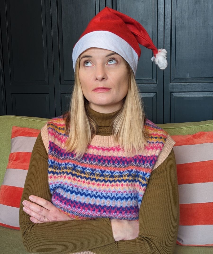 Pretty woman in Santa hat rolling her eyes.